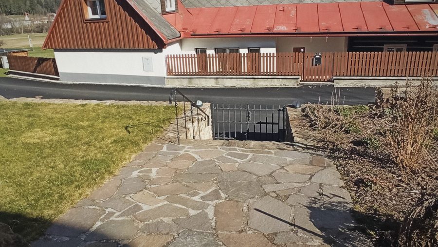 Dlážděný chodník a trávník na dvorku